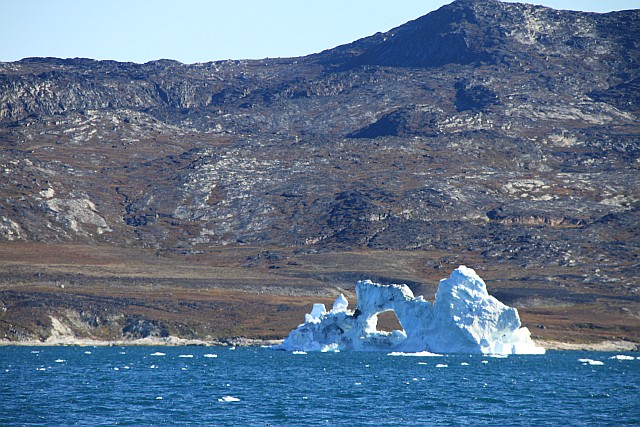 The icebergs make a beautiful foreground to the desolate Arctic landscape behind them.